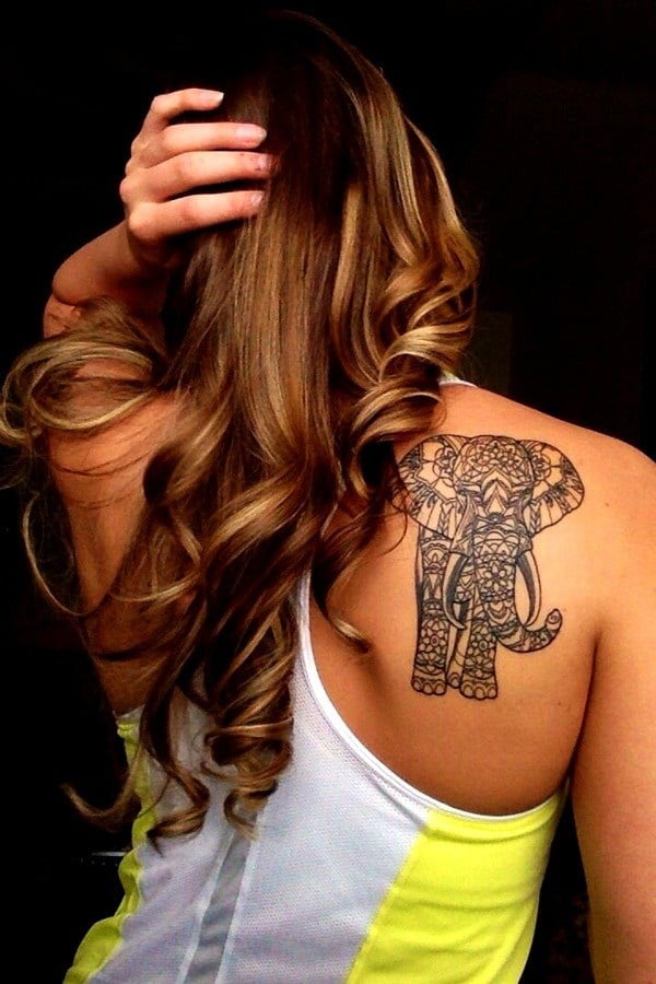 A beautifully decorated mandala elephant tattoo on the shoulder of a lady