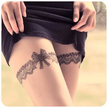 Grey Ink Bow Tattoos On Back Thigh by Jamie