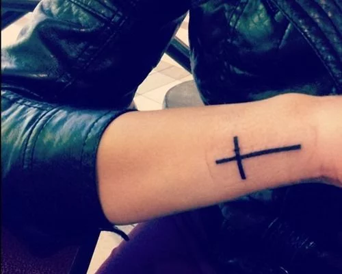 Cross tattoo on the side of Jaynells left wrist