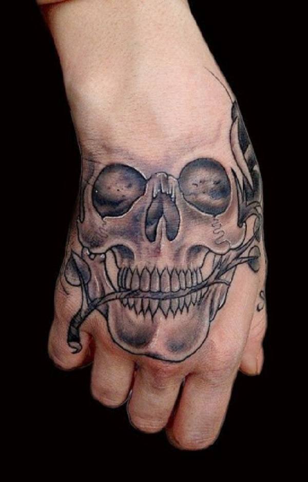 Romantic skull tattoo with a rose in its teeth on a hand