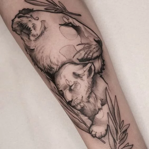 Black and grey lioness and cub tattoo on the thigh