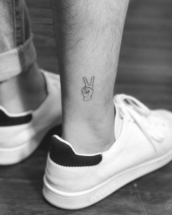 Tiny Hand Holding Up Two Fingers ankle tattoos by tattoo shop