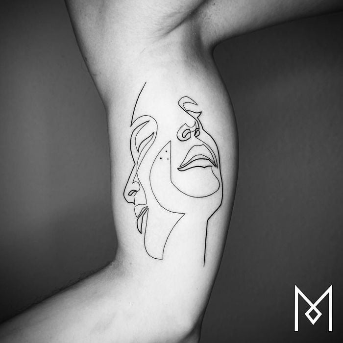 Single Line Creates Merged Faces on this Inner Bicep Tattoo Ideas