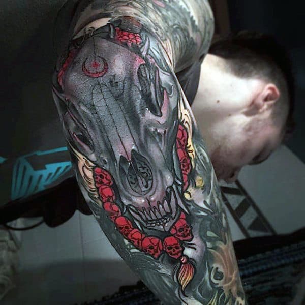 Decorated Canine Skull Tattoo with Chain of Human Skulls Elbow Tattoos with Deep Meaning