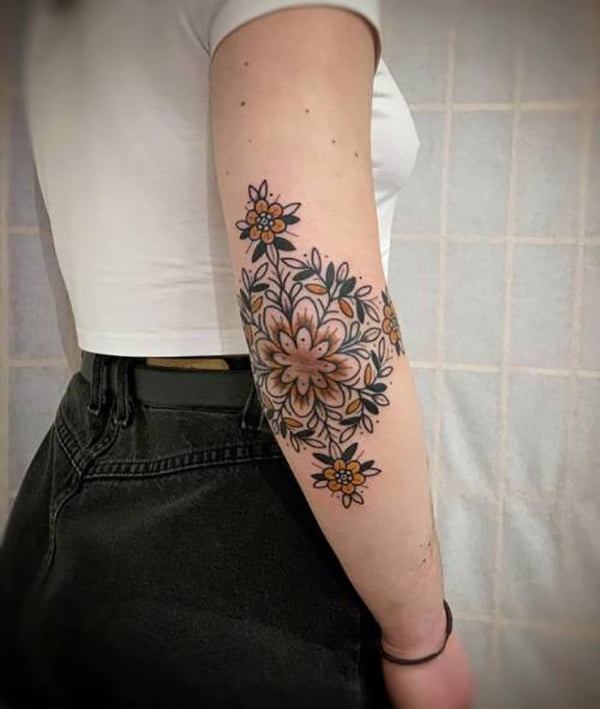 Yellow Flower Pattern Surrounded by More Flowers Elbow Tattoos