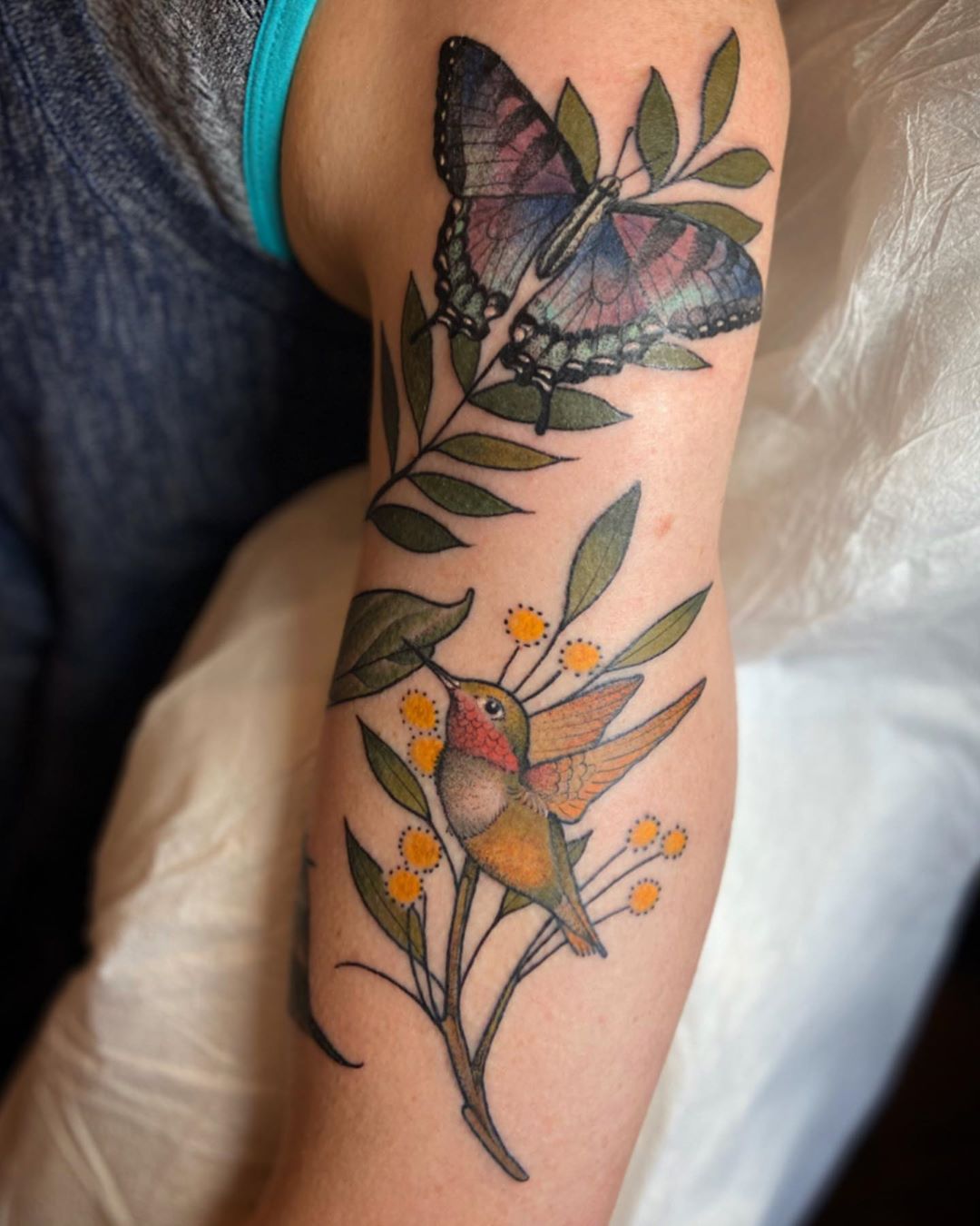 Butterfly and Hummingbird Tattoo Perching on Green Leaves